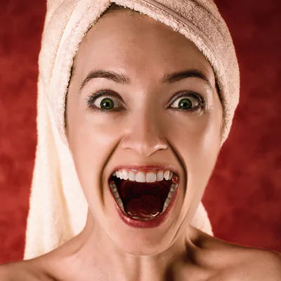 Lachende Frau mit Handtuch auf dem Kopf